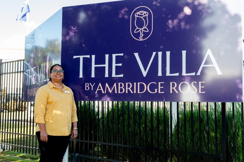 Ambridge Rose Nurse Manager Doreen Sami standing in front of The Villa signage