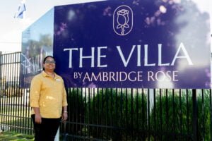 Ambridge Rose Nurse Manager Doreen Sami standing in front of The Villa signage